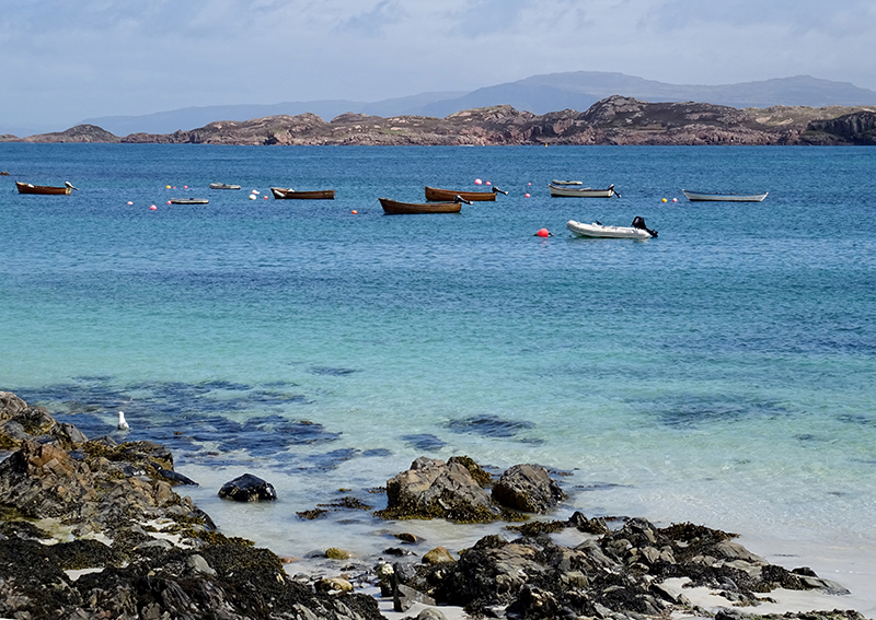 Small boats on the   turquoise blue waters of Iona © 2015 Scotiana
